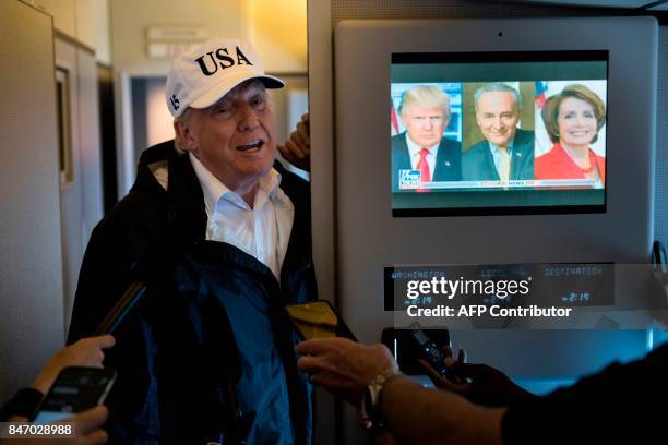 President Donald Trump speaks to the press onboard Air Force One while flying back to Andrews Air Force Base September 14, 2017 over, Florida. / AFP...