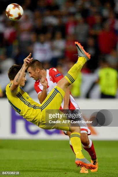 S midfielder Evgeni Berezkin vies with Crvena zvezda's midfielder Nenad Krsticic during the UEFA Europa League match between Crvena Zvezda and BATE...