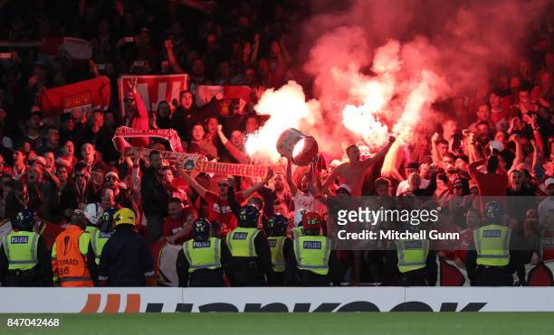 Police look on as Cologne fans ignite flares and celebrate a goal during the UEFA Champions League group C match between Chelsea FC and Qarabag FK at...