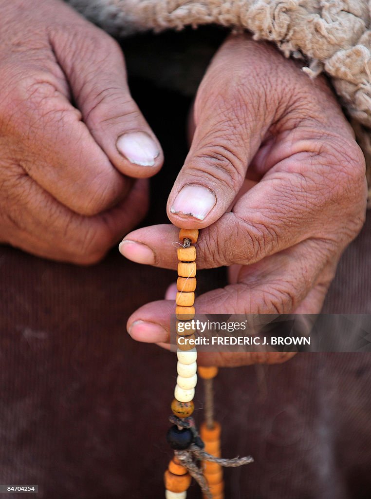 A woman prays with prayer beads at the N