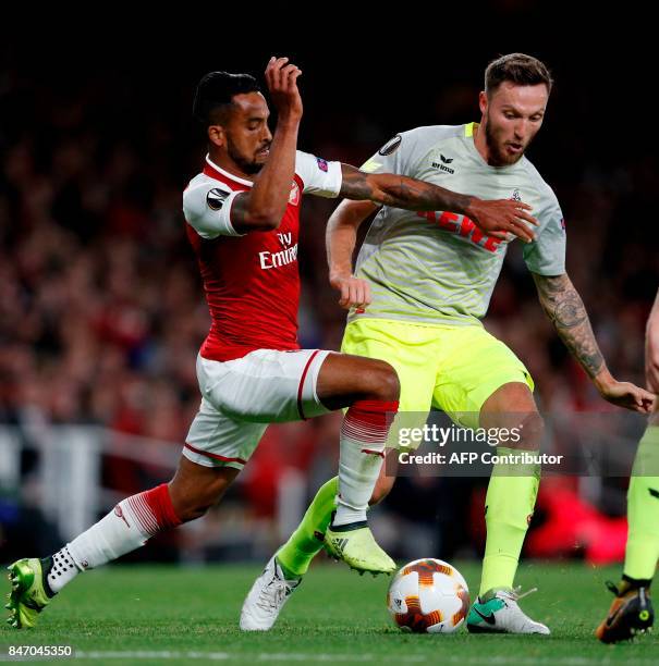 Arsenal's English midfielder Theo Walcott vies with FC Cologne's German midfielder Marco Hoger during the UEFA Europa League Group H football match...