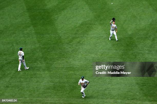 Boog Powell of the Oakland Athletics catches a fly ball hit by Mookie Betts of the Boston Red Sox during the seventh inning at Fenway Park on...