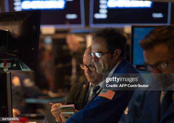 Traders work on the floor at the closing bell of the Dow Industrial Average at the New York Stock Exchange on September 14, 2017 in New York. The Dow...