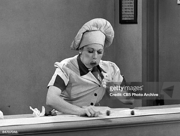 American comedienne and actress Lucille Ball , as Lucy Ricardo, work at a candy factory conveyor belt on an episode of the television comedy 'I Love...