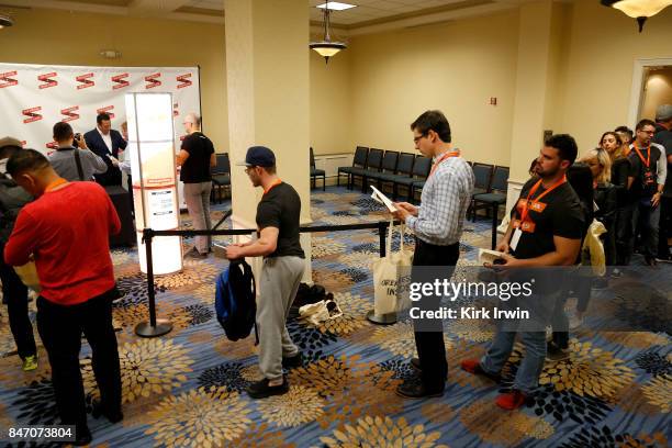 Chris Lee signs a copy of his book as attendees wait in line for their chance to get their books signed during the Summit of Greatness on September...