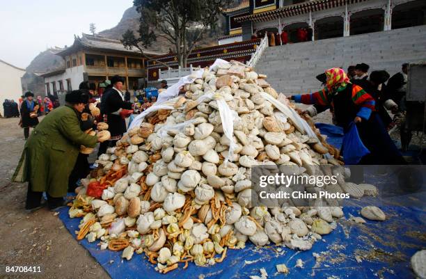 Villagers donate their bread to lamas as offerings during the "Tiaoqian" praying ceremony at the Youning Temple on February 8, 2009 in Huzhu County...