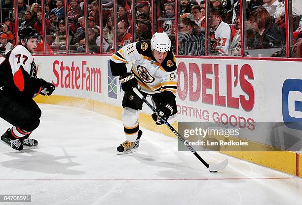 Marc Savard of the Boston Bruins skates the puck along the boards against Ryan Parent of the Philadelphia Flyers on February 4, 2009 at the Wachovia...