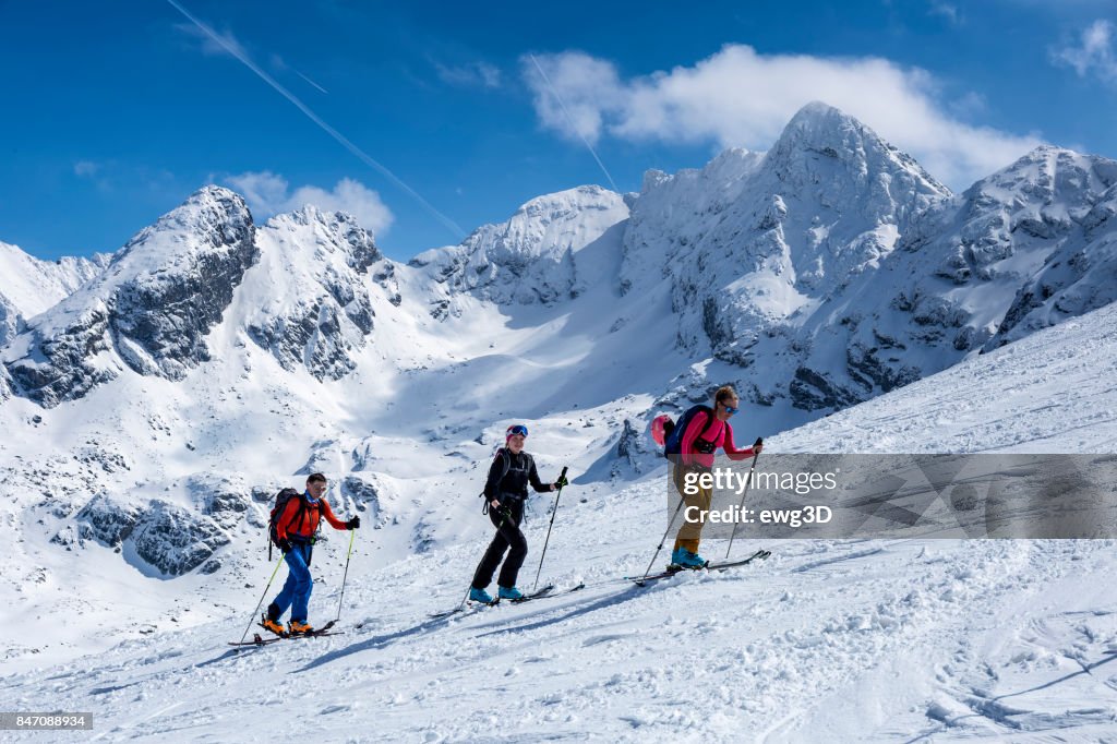 Three skiers go uphill on the ski slope, Tatra Mountains