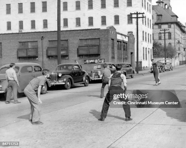 Group of boys play stickball on the street, Cincinnati, Ohio, ca.1930s.