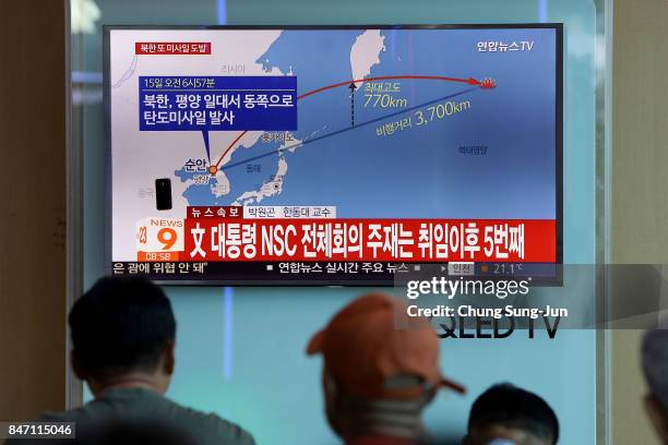 People watch a television broadcast reporting the North Korean missile launch at the Seoul Railway Station on September 15, 2017 in Seoul, South...