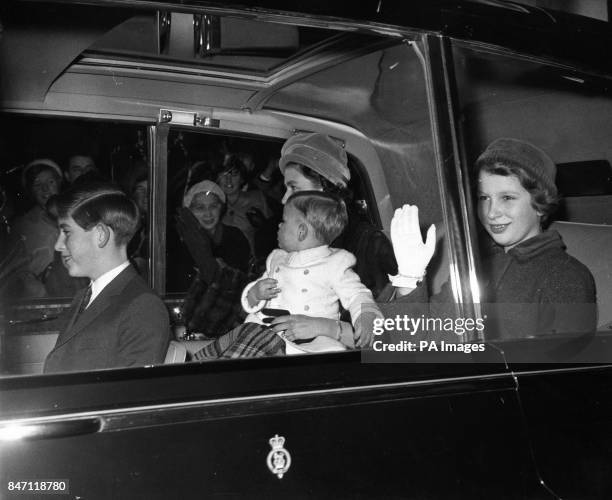 *Scanned low-res from print* Queen Elizabeth II with the Prince of Wales, Princess Anne and baby Prince Andrew driving from Buckingham Palace to...