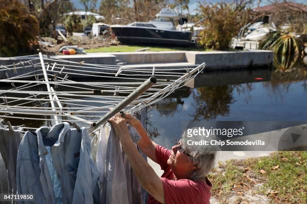 Nancy Heater hangs clothes to dry in her yard, September 14, 2017 on Big Pine Key, Florida. Across the canal from Heater, a neighbor's boat is seen...