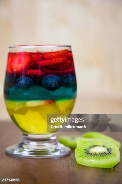 rainbow jello with strawberry's, blueberry and nectarine, homemade dessert - grape jelly stock pictures, royalty-free photos & images