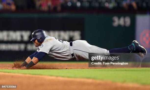 Nelson Cruz of the Seattle Mariners dives into second base safe on a wild pitch by Andrew Cashner of the Texas Rangers in the top of the third inning...