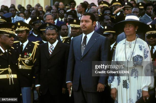 President of Haiti Jean-Claude Duvalier, a pistol in hand, accompanied by his mother Simone Duvalier at an official ceremony in April 1978 in...