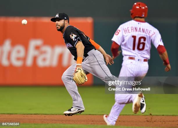 Mike Aviles of the Miami Marlins flips the ball to second base to put out Cesar Hernandez of the Philadelphia Phillies in the eighth inning at...