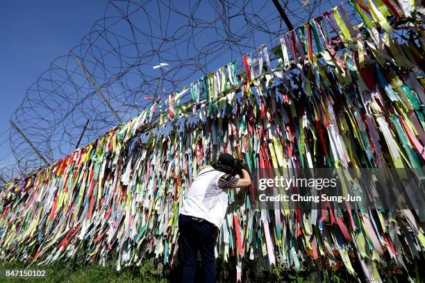 South Korean looks over a ribbon wishing for reunification of the two Koreas on the wire fence at the Imjingak Pavilion, near the demilitarized zone...