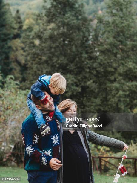 happy family playing together during christmas period - hands covering eyes stock pictures, royalty-free photos & images