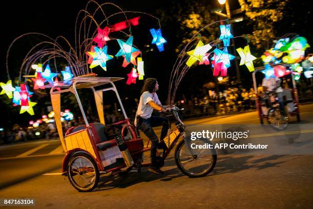 Pedi-cab operators weave their lantern-decorated cycles in choreographed movements for the grand opening of Chinese artist Cai Guo-Qiang's latest...