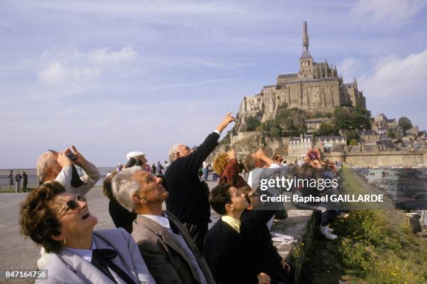 People looking up to archangel Saint Michel statue back at the top of abbey by helicopter after restoration on October 4, 1987 in Le Mont Saint...