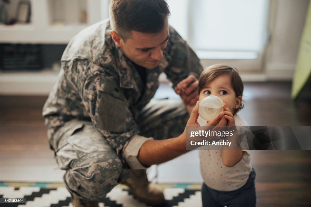 US soldier feeding his baby girl