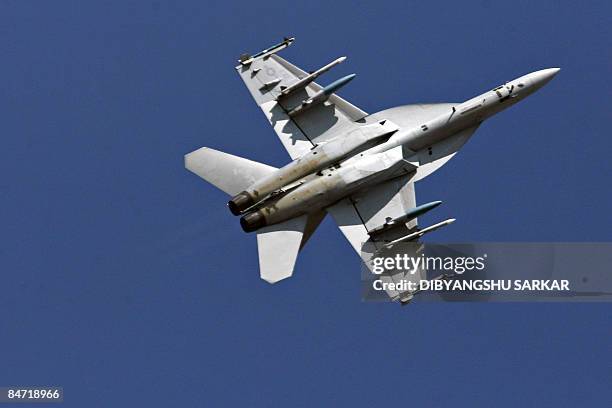 Navy F/A-18F Super Hornet strike aircraft performs a roll during a flight demonstration at the Yelahanka Air Force Station in Bangalore on February...