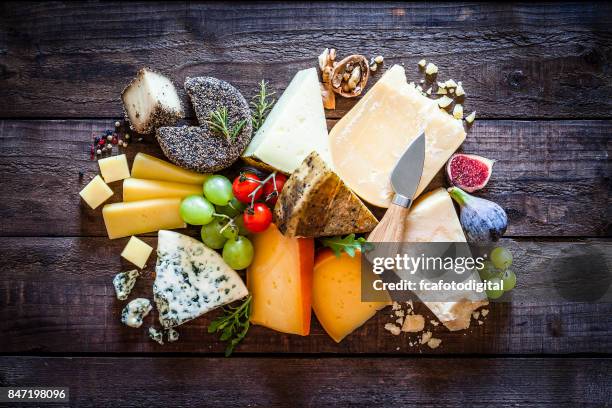 different types of cheeses on rustic wood table - cheese platter stock pictures, royalty-free photos & images