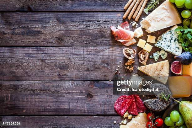 verschiedene arten von käse auf rustikalen holztisch - wurst stock-fotos und bilder