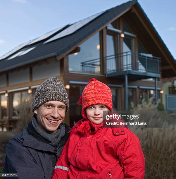 father and daugher in front of house - bavarian man in front of house stockfoto's en -beelden