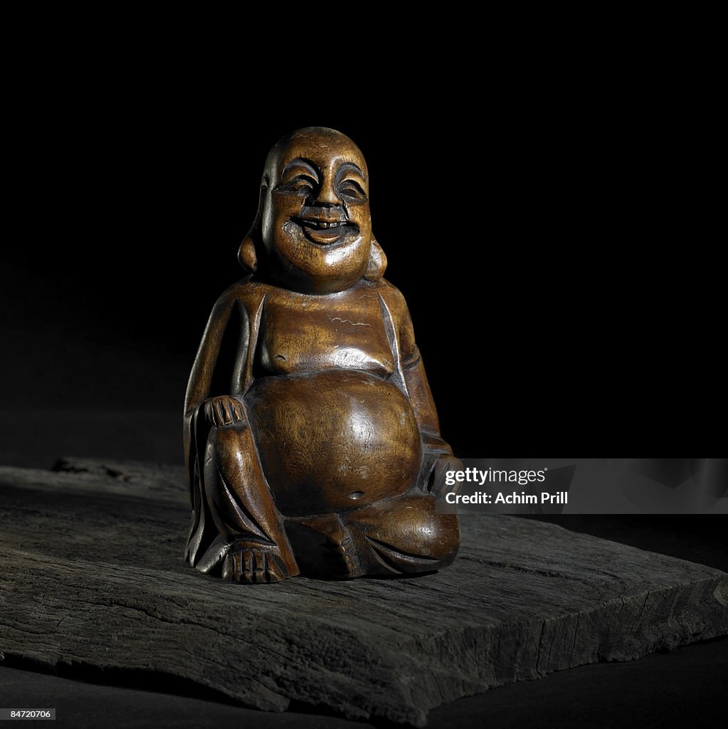 Wooden Buddha sculpture in dark back