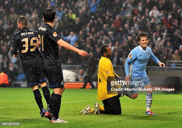 Manchester City's David Silva celebrates after scoring his team's third goal as FC Porto's goalkeeper Da Silva Helton looks on dejected