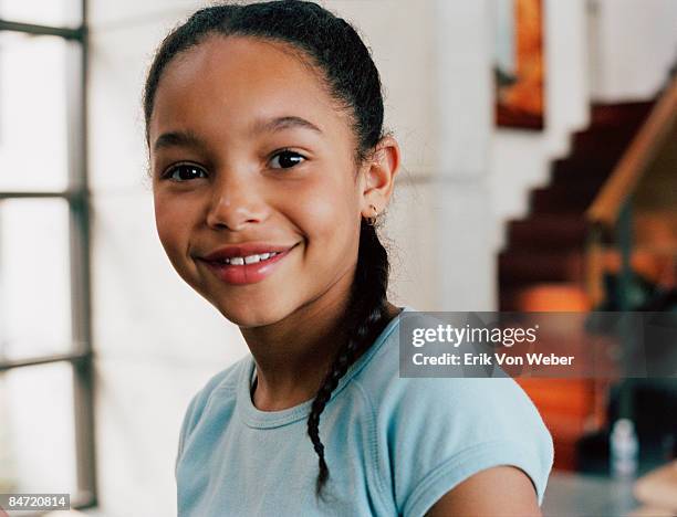 young girl looking at camera and smiling indoors - childs pose stockfoto's en -beelden