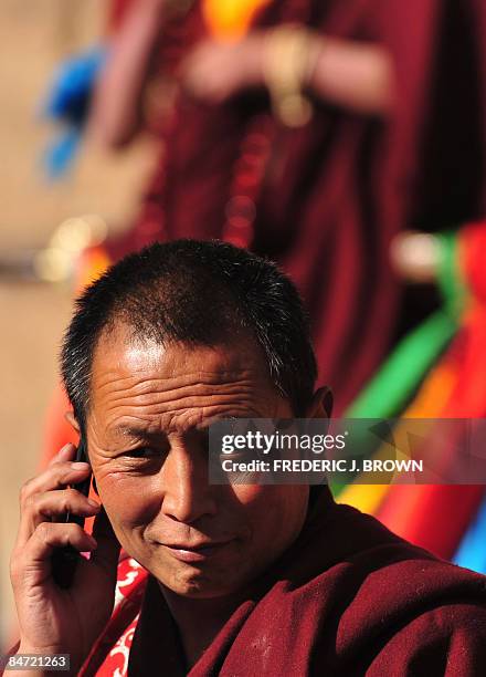 Tibetan Buddhist monk on his mobile phone during ongoing celebrations for Monlam, or the Great Prayer Festival, at the Nyentog Monastery, also known...