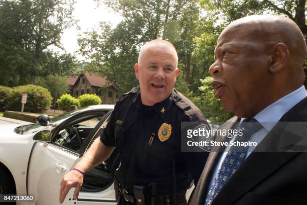 American politician and Civil Rights activist US Representative John Lewis speaks with a police officer outside the Montreat Conference Center during...