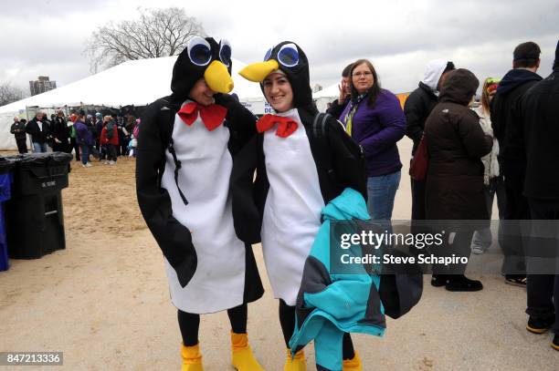 Portrait of two people, in matching penguin costumes, as they pose on North Avenue Beach during a Chicago Polar Plunge event, Chicago, Illinois, 2010.