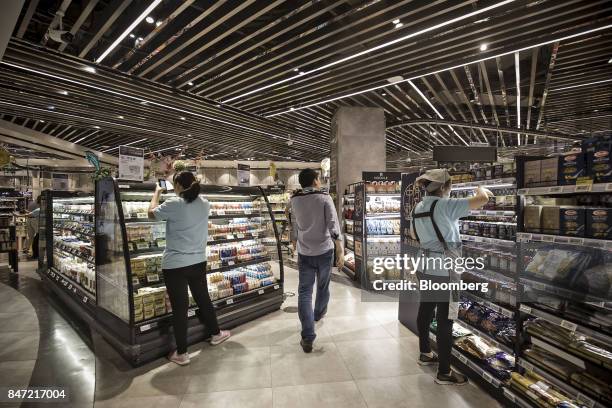 Customer walks through an Alibaba Group Holding Ltd. Hema Store as employees stock shelves in Shanghai, China, on Tuesday, Sept. 12, 2017. Hema...