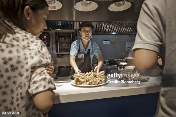An employee brings out a plate of freshly prepared shrimp at an Alibaba Group Holding Ltd. Hema Store in Shanghai, China, on Tuesday, Sept. 12, 2017....