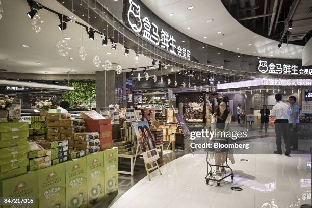 Customer pushes a shopping cart while browsing in an Alibaba Group Holding Ltd. Hema Store in Shanghai, China, on Tuesday, Sept. 12, 2017. Hema...