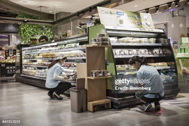 Employees stock shelves at an Alibaba Group Holding Ltd. Hema Store in Shanghai, China, on Tuesday, Sept. 12, 2017. Hema stores are one-stop shops...