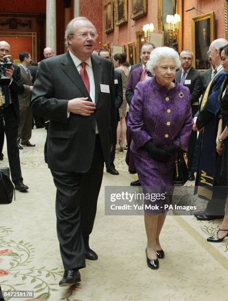 Queen Elizabeth II is accompanied by Kieran Poynter, Chairman of The Royal Anniversary Trust, during a Royal Anniversary Prizes Reception at...