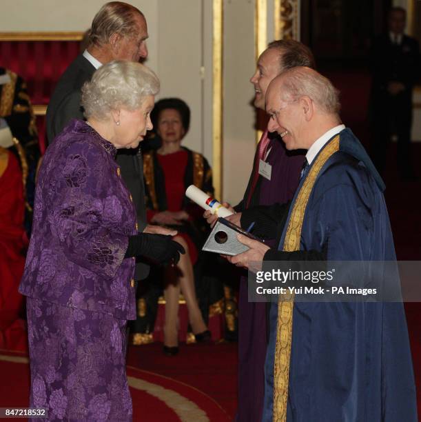 Queen Elizabeth II and The Duke of Edinburgh present a Royal Anniversary Prize for Higher and Further Education to Professor Sir John O'Reilly and...