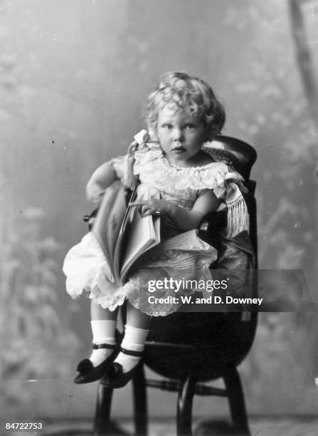 Prince Edward Albert , later King Edward VIII and the Duke of Windsor, seated in a high chair with a book, 1896.