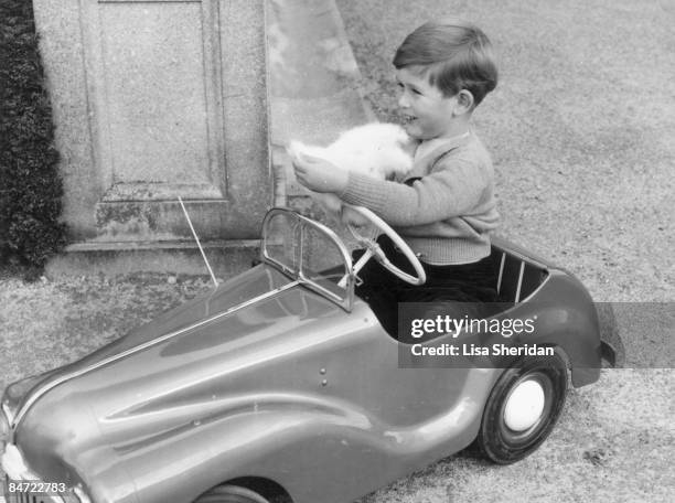 Prince Charles plays in a miniature car in the grounds of Balmoral Castle in Scotland, September 1952.