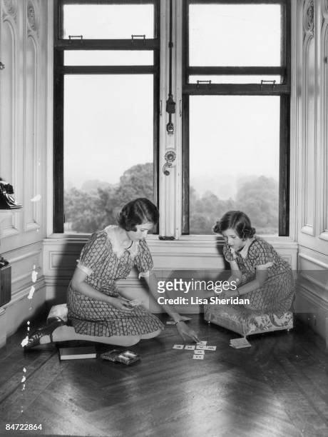 Princess Elizabeth and Princess Margaret play a card game at the Royal Lodge, Windsor, 22nd June 1940.