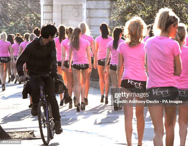 Cyclist is distracted as 100 girls wearing hot pants walk across central London during the launch of Veet EasyWax's nationwide competition to search...