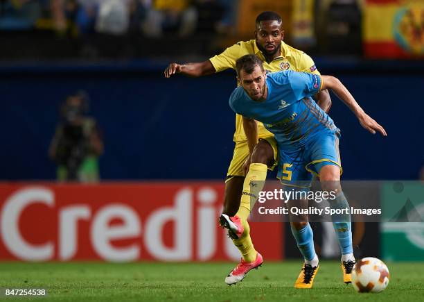 Cedric Bakambu of Villarreal competes for the ball with Marin Anicic of Astana during the UEFA Europa League group A match between Villarreal CF and...