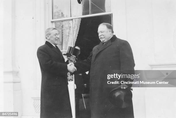 On the right, losing incumbent William Howard Taft congratulates incoming president Woodrow Wilson at the latter's inauguration in Washington, DC,...