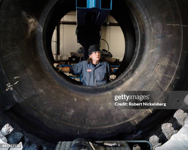 Tire mechanic repairs a 12-foot diameter tire at the Big Horn Tire Shop in Gillette, Wyoming, June 15, 2006. Giant tires are used on earth moving...
