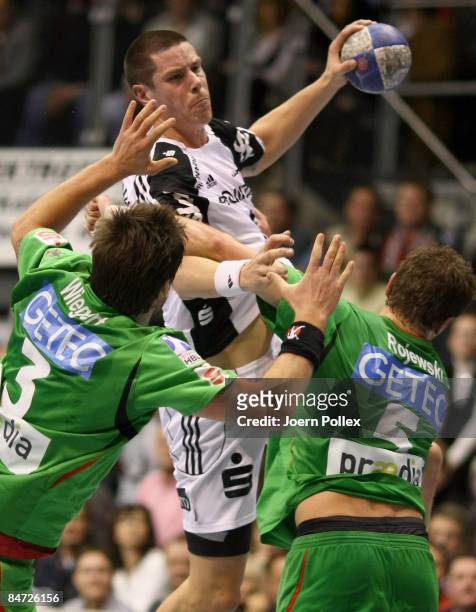 Kim Andersson of Kiel is attacked by Bennet Wiegert and Andreas Rojewski of Magdeburg during the Toyota Handball Bundesliga match between SC...