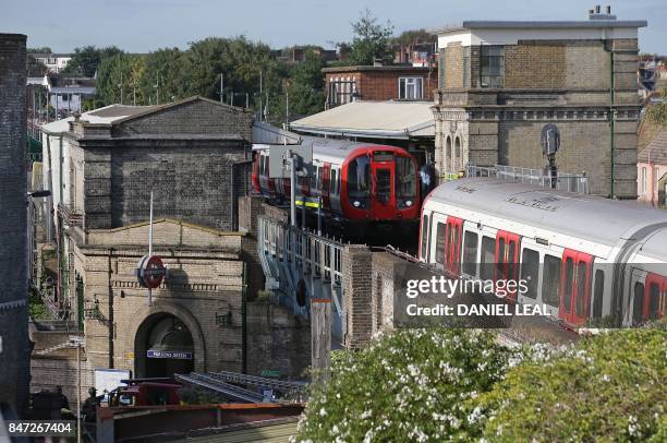 Members of the emergency services and armed police officers work alongside an underground tube train at a platform at Parsons Green underground tube...